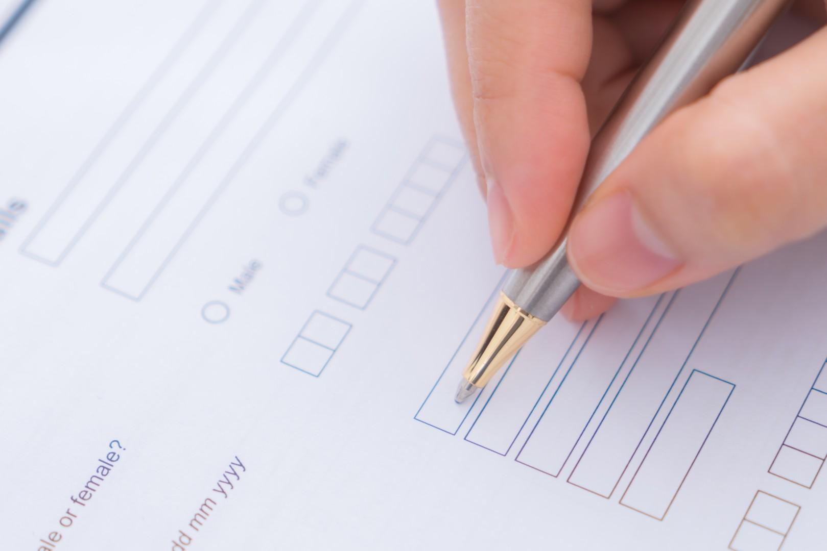 Hand with pen over application form